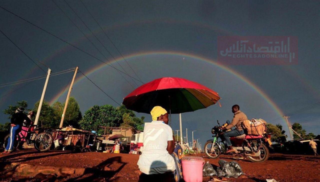 تصویر زیبای رنگین‌کمان مقابل زن دستفروش +عکس