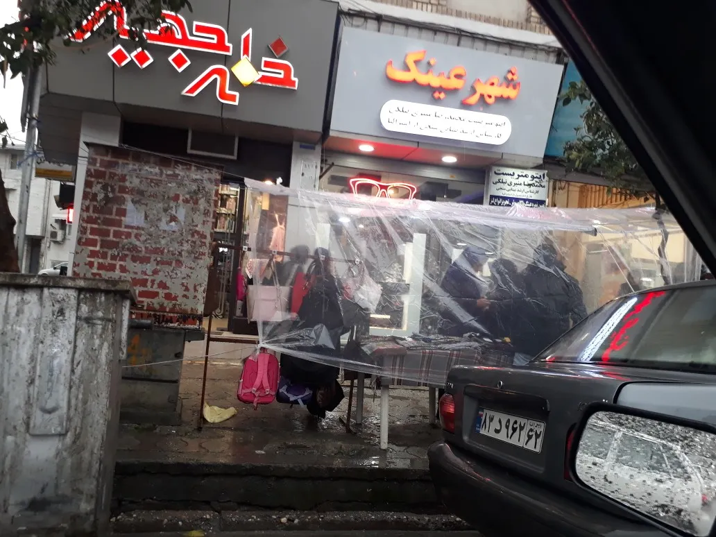 ابتکار دستفروشان ساروی برای فروش در زیر باران +تصاویر